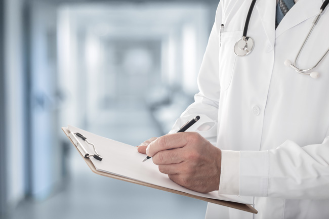 Healthcare worker writing on a clipboard, whose office uses Optima's fractional CFO services