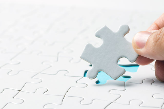 hand placing final puzzle piece representing Optima's personalized solutions